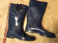 Side view of both blue ladies rain boots showing height and design.
