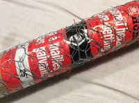 Close-up of the unopened roll of hexagonal galvanized wire netting showing the metal mesh and product label.
