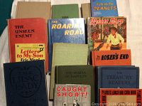 Overview of vintage books with visible titles including The Roaring Road, The Loser's End, Fun with Peanuts, and Letters to My Son.