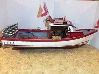 Side view of both the large fishing boat model and smaller dinghy on floor