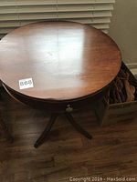 Top view of round tabletop showing surface and one drawer closed