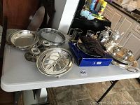 Full view of all items included in the lot on a white folding table in a kitchen area.