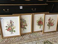 Group shot of four framed floral prints leaning against furniture