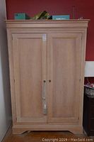 Front view of pine armoire showing full height, two doors, and wood finish.