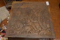 Top view of the square carved wood coffee table showing the detailed elephant and nature relief carving.