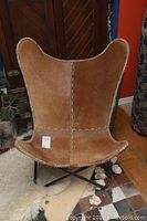 Front view of brown hide seat with stitched seams on black metal frame