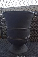 Full view of a 21-inch tall black resin planter showing overall shape and texture