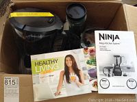 Contents of the Ninja Mega Kitchen System including the crushing pitcher and owner's guide inside a box.