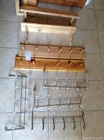 Wooden wall-mounted coat racks and shelf unit with metal over-the-door hooks on floor