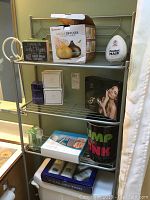 Overall bathroom shelf with contents including Lancome perfume, Forever Flawless boxes, aroma diffuser, electronic scale, and other items.