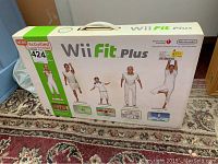 Front and top view of the Nintendo Wii Fit Plus video game box featuring exercise activity images.