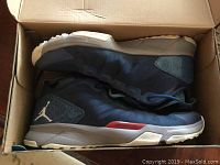 Photo inside the open sneaker box showing the navy blue Adidas Michael Jordan sneakers with visible Jumpman logo.