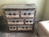 Front view of small distressed wood dresser with 6 drawers and rope handles.
