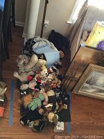 Multiple teddy bears, Boyds Bears visibly dressed in nurse and doctor outfits, assorted bears including Baby Gund and Annette Funicello, arranged on floor near a corner of a room