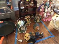 Photo showing the Boyds Bears figurines, Boyds Bear light, bride and groom figurines, small wooden display shelf, and several Scottie dog figurines arranged on a floor with a frying pan visible
