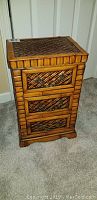 Front view of the small decorative drawer unit showing three drawers with carved bamboo pattern.