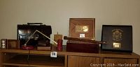 Overview photo of the lot showing two humidors, wooden desk items, small desk lamp, and large wooden compass on shelf.