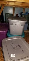 Stacked plastic storage tubs labeled 'Xmas' in attic