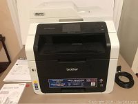 Full front view of printer with scanner lid closed, user guides in background