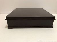 Closed wooden tea caddy box showing smooth dark wood finish and rectangular shape