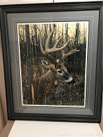 Front view of framed print showing deer portrait in black frame with double mat