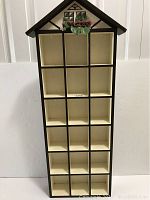 Front view of the eighteen section hanging display cabinet showing the house shape and walnut finish.