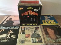 Box set of K-tel Presents Lighthouse 20 Great Hits with visible album spines behind it and Elvis LP cover to the side among others.