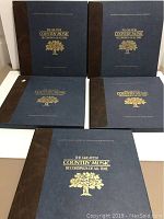 Five hardcover albums with blue and brown covers titled 'The Greatest Country Music Recordings of All Time' from Franklin Mint
