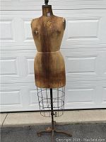 Full view of the mannequin showing fabric torso, metal cage lower half on adjustable rod stand.