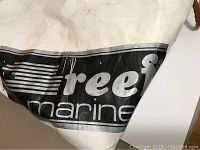 Close-up showing white PVC material with black Reef Marine logo on the lift bag.