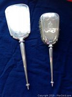 Full view of sterling silver hand mirror set with brush, showing length and design.