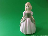 Full view of Royal Doulton Penny figurine showing front with pink and green dress and blonde hair.