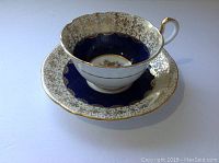 Cup placed inside matching saucer showing interior pattern and gold detailing.