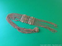 Full view of the vintage gold plated necklace laid flat, showing the length and multi-strand chain arrangement with central decorative elements.