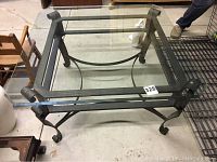 Top view showing clear square glass surface and iron frame beneath.