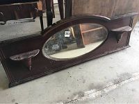 Full view of the wood dresser mirror showing the oval beveled glass center and two side shelves.