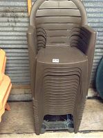Stack of 18 brown plastic chairs neatly nested