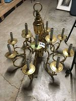 Full overhead view of brass chandelier with 12 light sockets arranged in a circular pattern and decorative chain loop top section.