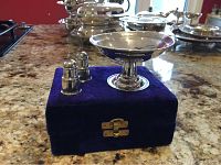 Items are placed on a blue velvet case on a granite countertop. Salt and pepper shakers shown next to the pedestal dish.