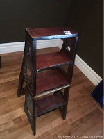 Full view of the wooden library chair ladder in folded ladder form showing its three steps and frame.