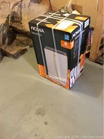 Boxed NOMA dehumidifier unit strapped upright on concrete floor
