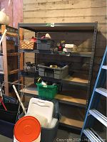 Full view of shelving unit with various items stored on shelves, showing overall condition and size.