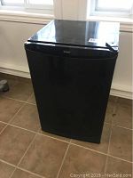 Full view of black Kenmore bar fridge showing scratches and overall condition.