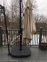 Full assembled patio umbrella with weighted base on deck