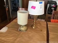Photo of two lamps on a table showing whole lamps with shades and cords.