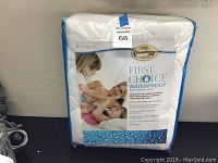 Front view of packaged First Choice waterproof mattress pad, showing brand, usage description, and product image on packaging.