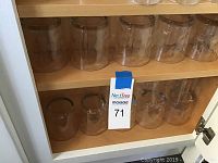 Glassware cabinet shelf showing 13 clear thumb print textured glasses arranged in two rows.