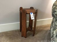 Front side view of small wood side table showing square top and legs with cross stretcher supports.