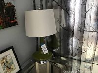 Table lamp with green bulbous ceramic or glass base, with chrome accent and white fabric drum shade.