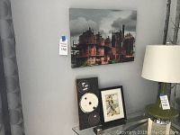 Full view of the lot showing the art print on the wall, magnetic board leaning on the glass table, small framed art on table, and a table lamp